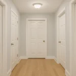 Couloir moderne avec plusieurs portes blanches alignées, illustrant comment harmoniser les couleurs dans un couloir aux multiples portes